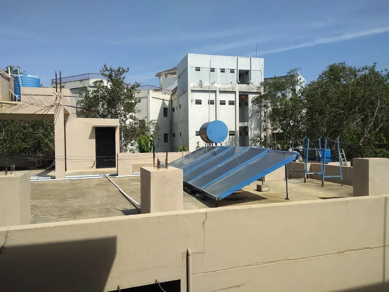 Solar water heater providing 24/7 hot water, with NIE campus behind