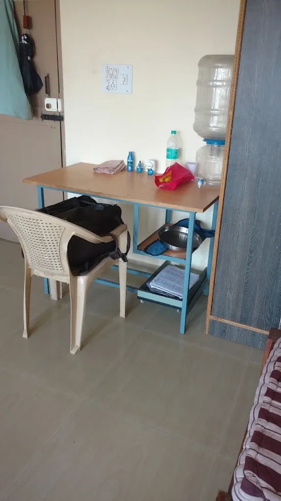Furnished PG room with study table, chair and wardrobe